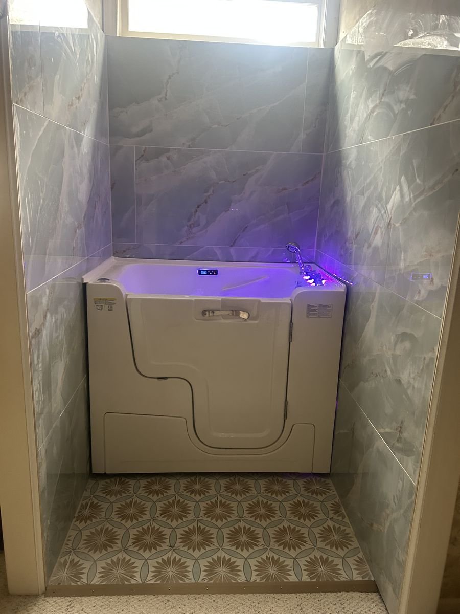 Walk-in tub with marble tile and LED lighting